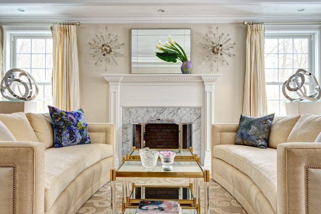 Carrara Fireplace surround, beige sofas, facing sofas, two coffee tables, symmetry, asymmetry, silk drapes